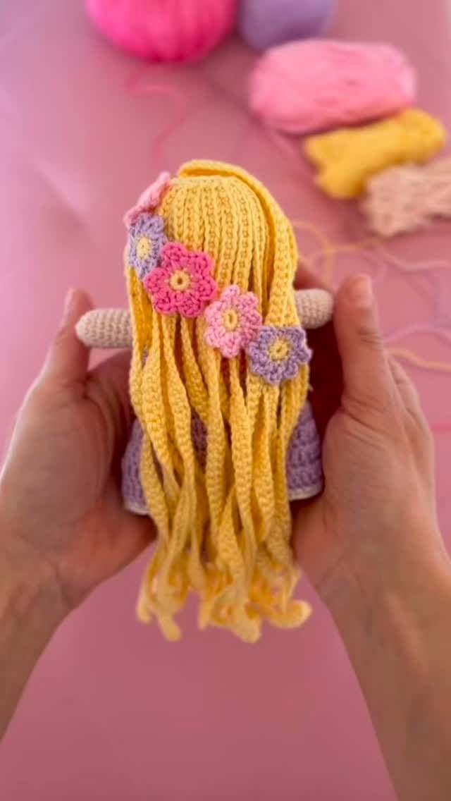 Amigurumi doll with long blonde hair and crochet flowers