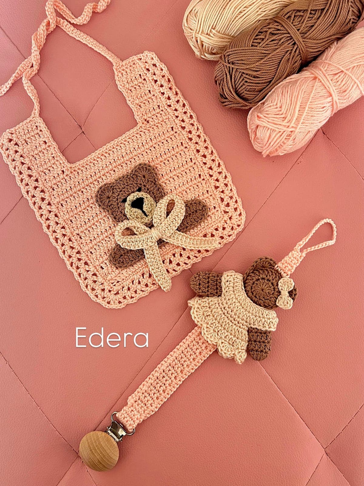 Pink crochet bib with a teddy bear and a matching pacifier clip