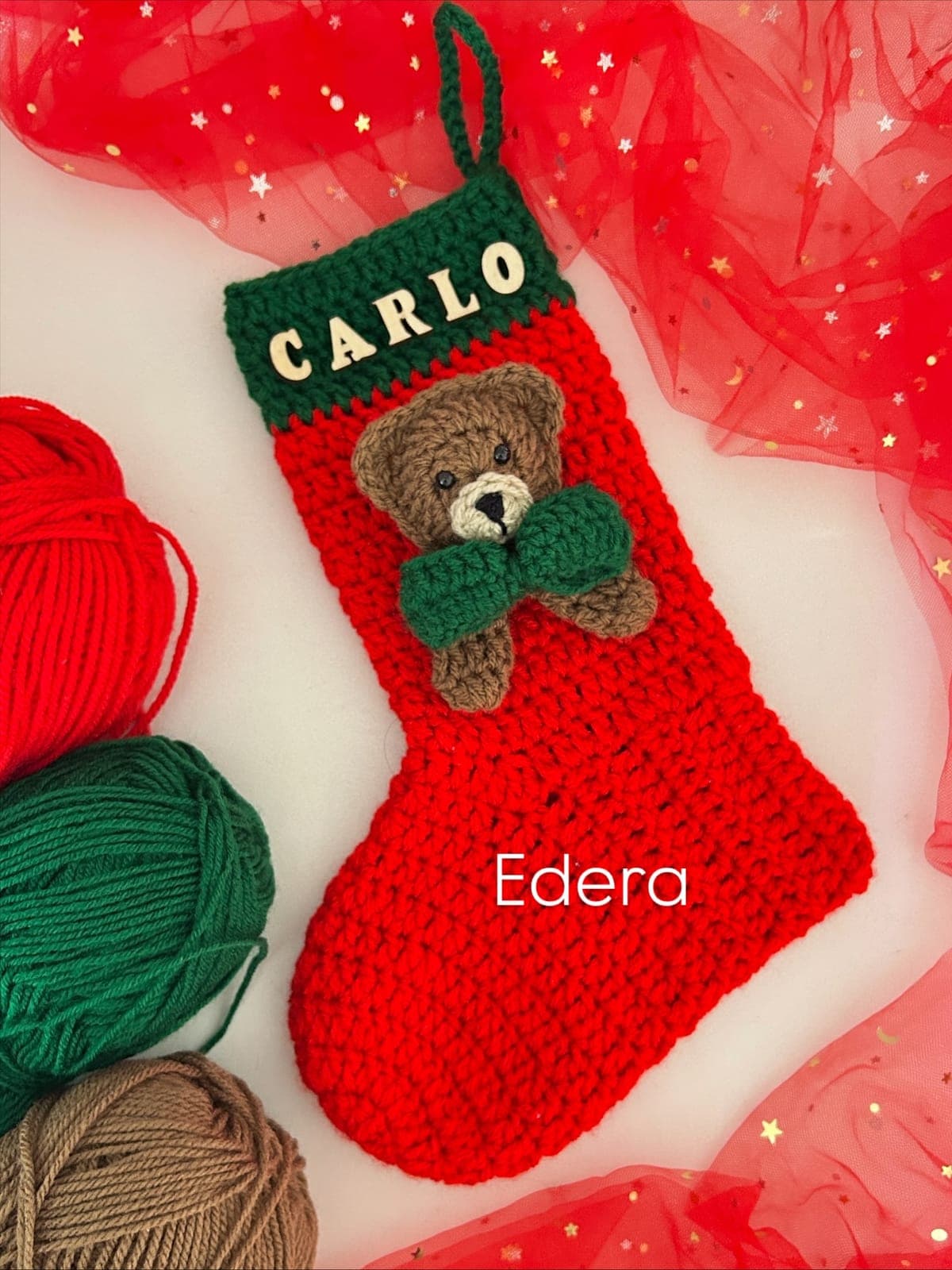 Red stocking with the name Carlo and a teddy bear with a green bow tie