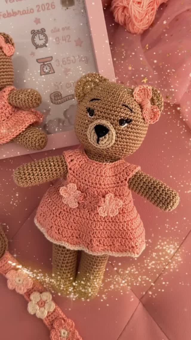 Amigurumi teddy in a pink crocheted dress with flowers
