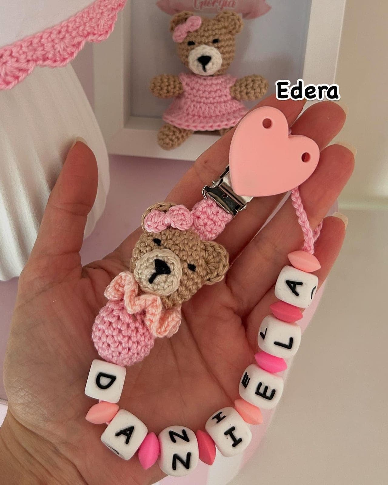 Pink pacifier clip with an amigurumi teddy and the name Daniela