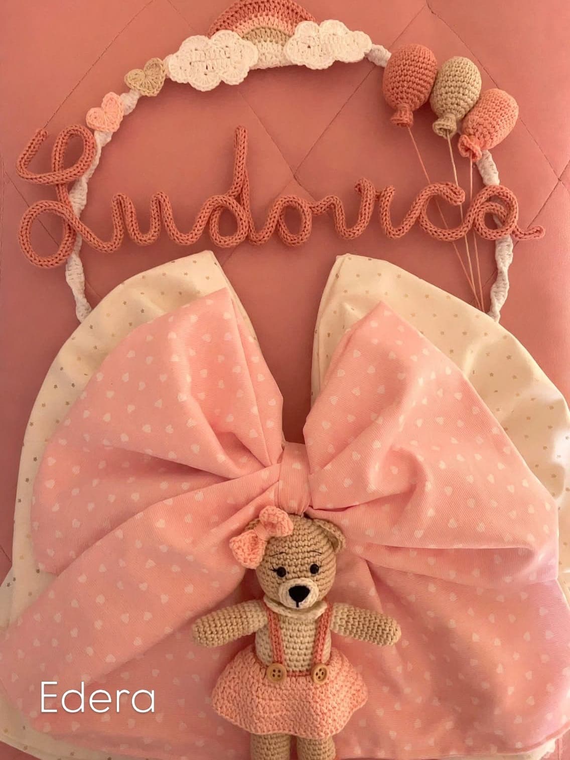 Pink birth announcement bow with the name Ludovica in yarn and an amigurumi teddy